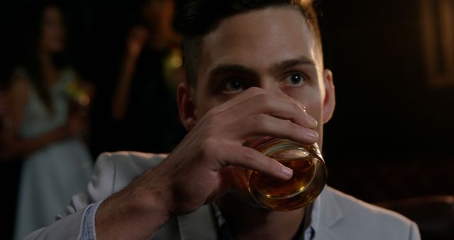 Young Man Drinking Whiskey in Dimly Lit Bar - Download Free Stock Images Pikwizard.com