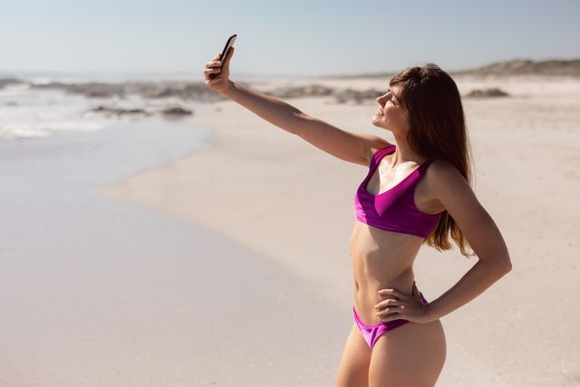 Beautiful woman in bikini taking selfie with mobile phone at beach in the sunshine - Download Free Stock Photos Pikwizard.com