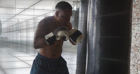 Shirtless boxer training hitting heavy bag showing focus strength and discipline