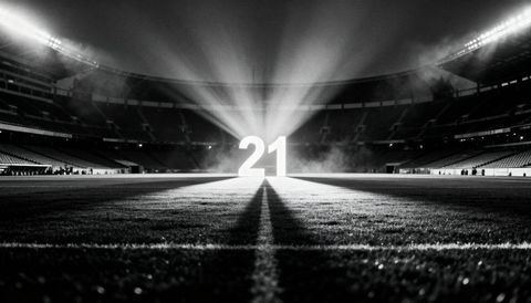 Giant glowing 21 on stadium field with dramatic spotlight beams at night