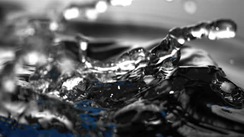 Blue Object Submerging in Rippling Water in Slow Motion