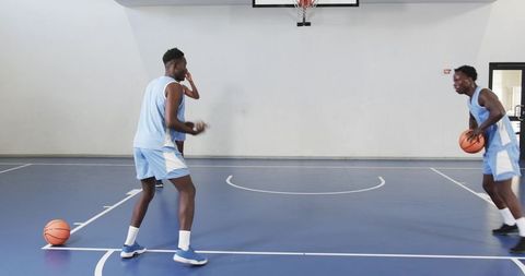 Basketball Teammates Practicing on Indoor Blue Court