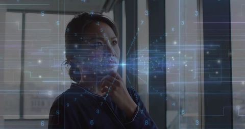 Asian Woman Analyzing Futuristic Digital Interface in Office