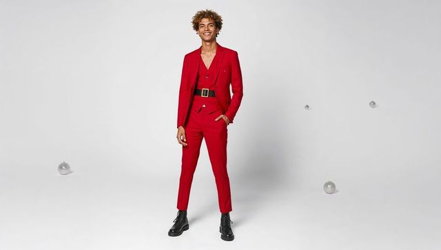 Stylish man in red suit standing against white background