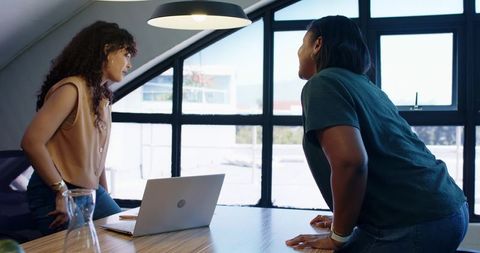 African american coworkers collaborating by windowed desk in bright modern office meeting