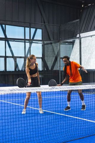 Diverse Athletes Practicing Padel on Vibrant Blue Court