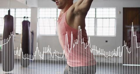 Athlete raising arms overhead in gym with performance graph overlay training motivation