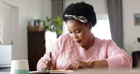 Focused Woman Writing in Notebook at Home Office Desk - Download Free Stock Images Pikwizard.com