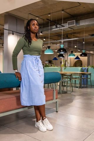 African american woman standing in modern coworking cafe with pastel industrial decor