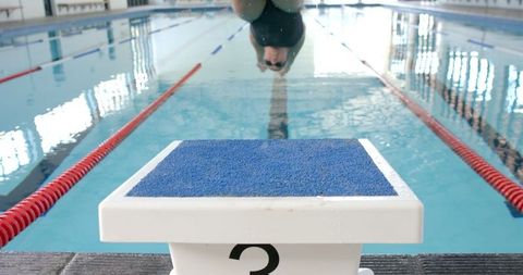 Swimmer Diving from Start Block into Pool