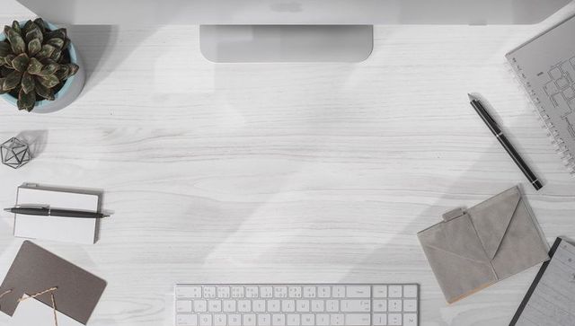 Minimal scandinavian home desk with compact wireless keyboard, succulent and notecards