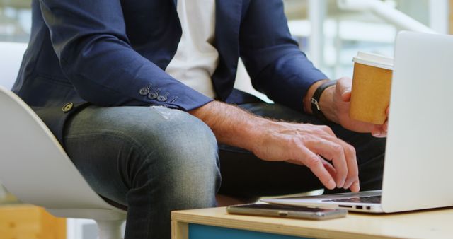 Businessman Working on Laptop and Holding Coffee - Download Free Stock Images Pikwizard.com