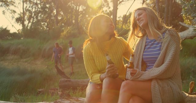 Friends Relaxing in Sunlit Forest Enjoying Bottled Beverages - Download Free Stock Images Pikwizard.com