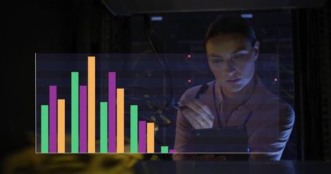 Woman analyzing data on tablet in server room