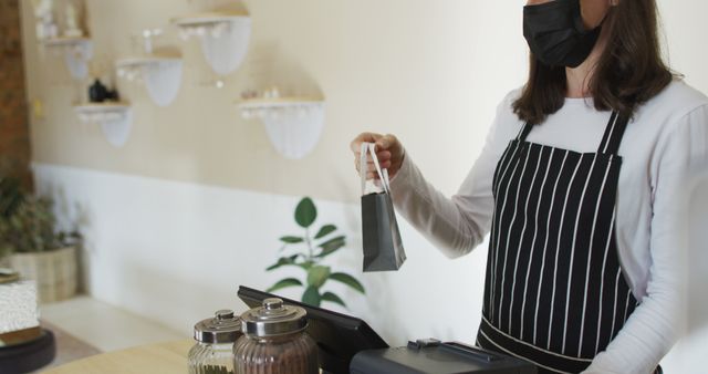 Barista in Facemask Holding Coffee Bag at Café Counter - Download Free Stock Images Pikwizard.com