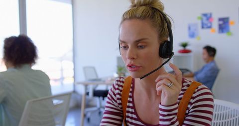 Focused customer service representative using headset at desk