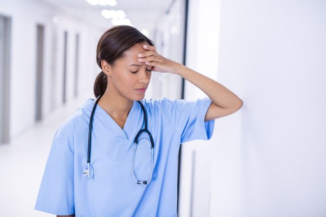 Tensed female doctor standing in corridor of hospital