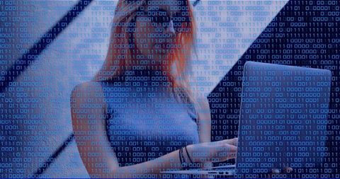 Typing Redhead Woman Working Remotely on Laptop with Binary Overlay