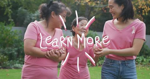 Multigenerational women supporting senior wearing pink ribbon in garden for breast cancer awareness