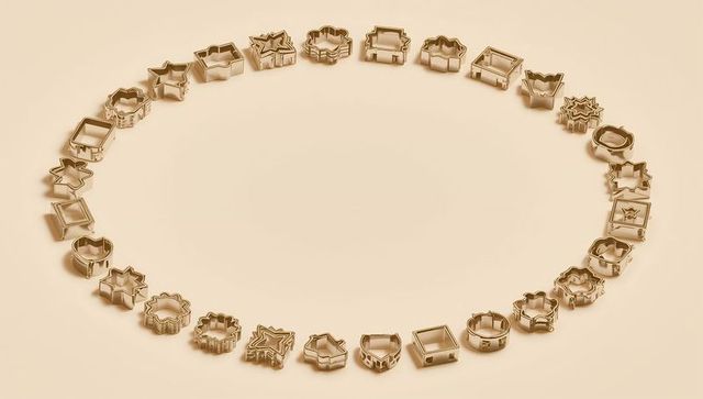 Gold cookie cutters ring forming empty center minimal flatlay with star heart crown shapes