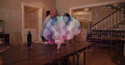 Couple arranging napkin on dining table with hexagonal digital overlay in cozy interior