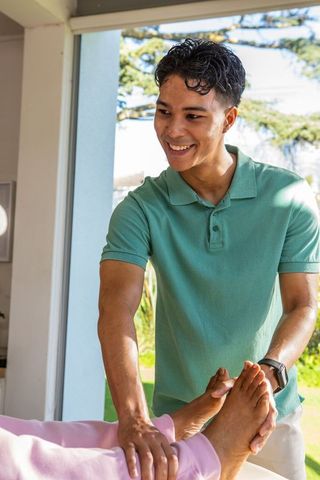 Smiling Therapist Guiding Foot Stretching Therapy Exercise