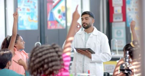 Science teacher engaging young students in classroom discussion