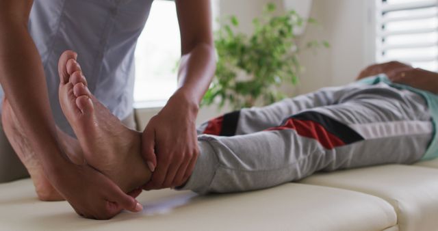 Biracial female physiotherapist helping senior man stretching his legs - Download Free Stock Photos Pikwizard.com