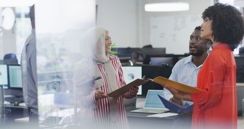 Diverse Team Collaborating in Modern Office Around Technology