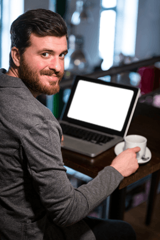 Bearded businessman in cafe with transparent laptop screen