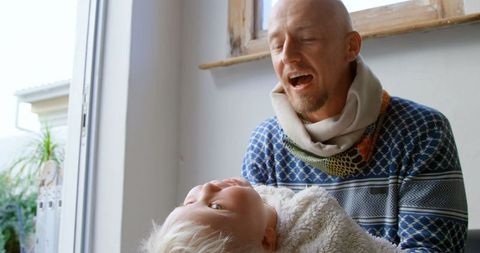 Caucasian Father Bonding with Daughter at Home on Bright Day