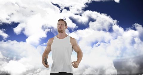 Athletic man practicing sports disc throw cloudy sky