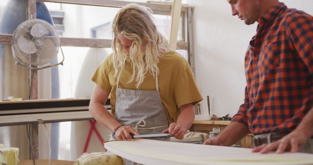 Two Craftsmen Working on Surfboard in Workshop - Download Free Stock Images Pikwizard.com