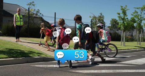 Schoolchildren crossing suburban crosswalk with hi-vis guard and notification bubble 53