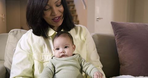 Mother Holding Baby Girl in Cozy Home Setting