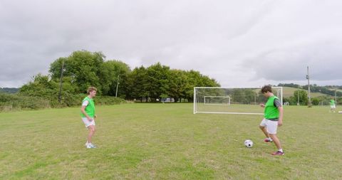 Teen Boys Practicing Soccer on Green Field in Team Jerseys