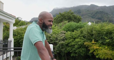 Man Enjoying Scenic Mountain View from Balcony