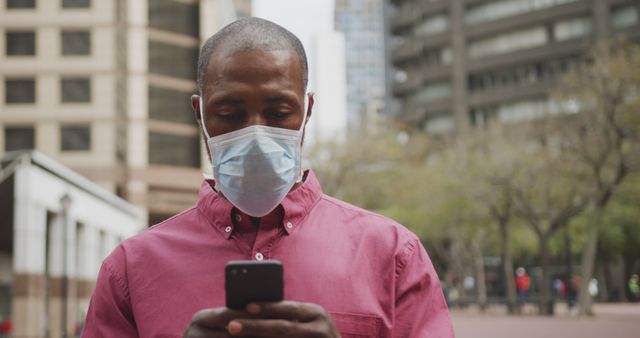 Man Wearing Mask Checking Phone Outdoors in City During Daytime - Download Free Stock Images Pikwizard.com