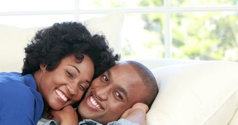 Happy Couple Relaxing on Sofa with Warm Smiles
