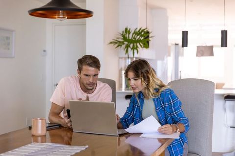 Couple collaborating on laptop in modern home interior