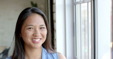 Businesswoman smiling near office window slow motion