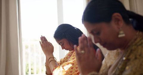 Mother and Daughter Praying Together in Unity and Faith