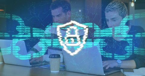 Cybersecurity team collaborating on laptops with digital shield and code overlay