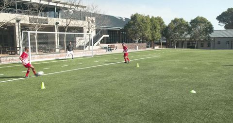 Young soccer player practicing dribbling at school field