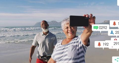 Sunlit Senior Couple Taking Beach Selfie with Smartphone and Social Media Notifications