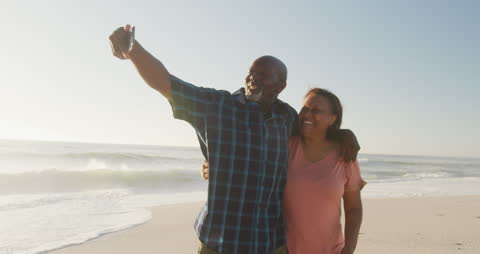 Senior Couple Capturing Beach Memories with Smartphone