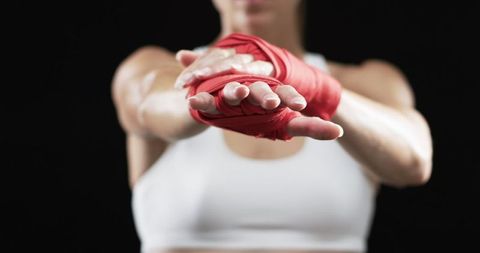Female Athlete with Red Hand Wraps in Pre-Workout Stretch