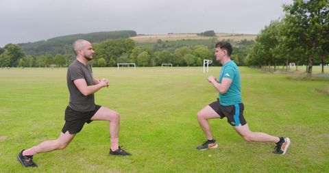 Two Men Doing Lunges in Park Training Outdoors