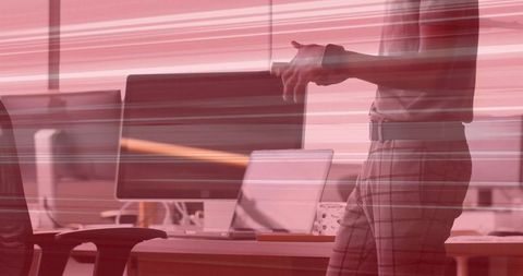 Gesturing professional in modern open office with glitch motion effect and dual monitors