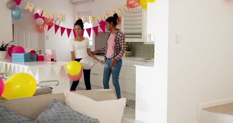 Women Decorating Home for Celebration with Colorful Balloons